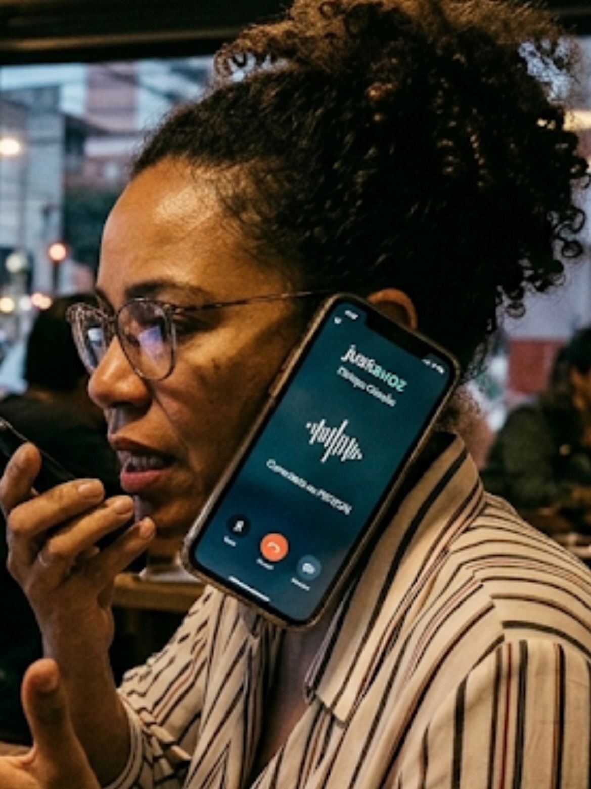 Cidadã em conversa por voz com a JustaVoz, em ambiente urbano cotidiano.